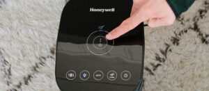 A person turning on a dorm air purifier in their dorm/apartment